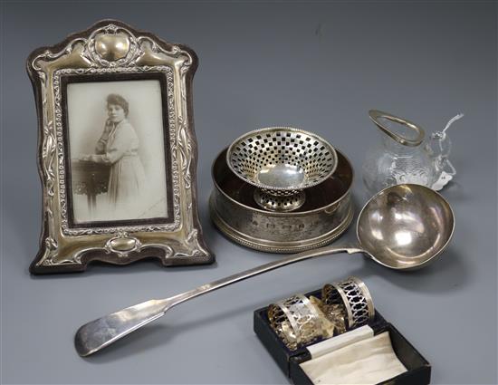 A modern silver coaster, a cased pair of silver napkin rings and other silver and plated items including a photograph frame.